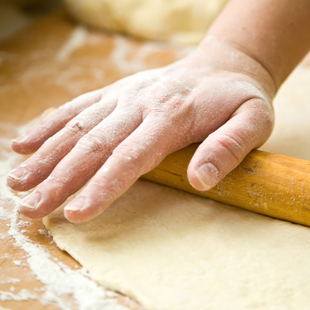 hand with rolling pin and flour