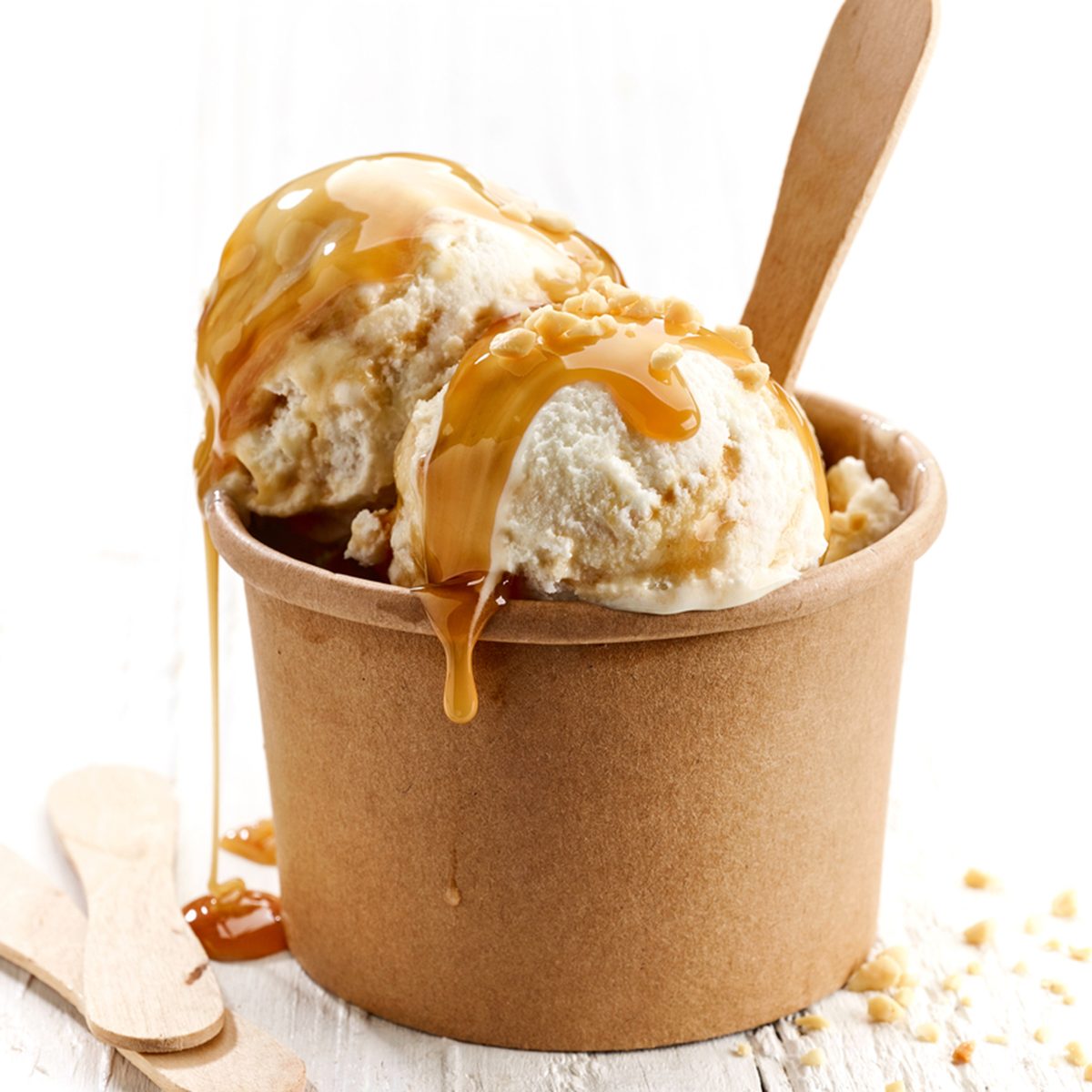 ice cream with caramel sauce and ground nuts on white wooden table; Shutterstock ID 512797333; Job (TFH, TOH, RD, BNB, CWM, CM): Taste of Home