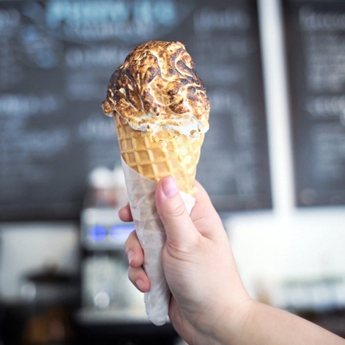 Ice Cream Cone in hand with Giant Scoop Toasted Marshmallow on Top; Shutterstock ID 632323022; Job (TFH, TOH, RD, BNB, CWM, CM): Taste of Home