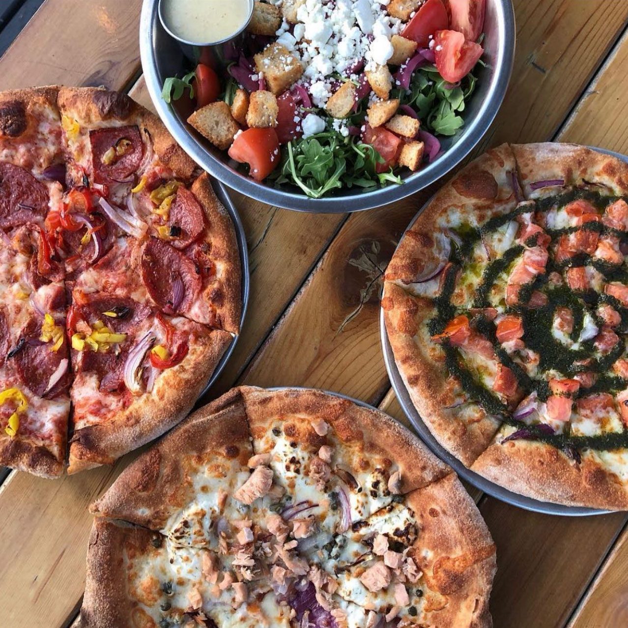 three pizzas and a salad, view from above