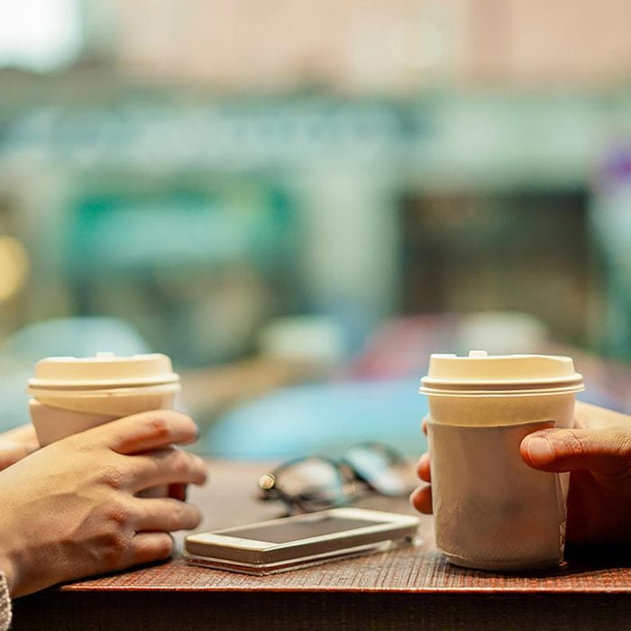 Two people sitting at table drinking coffee