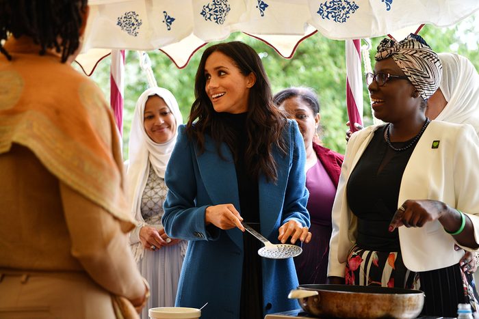 Meghan Duchess of Sussex helps to prepare food at the launch of a cookbook with recipes from a group of women affected by the Grenfell Tower fire at Kensington Palace