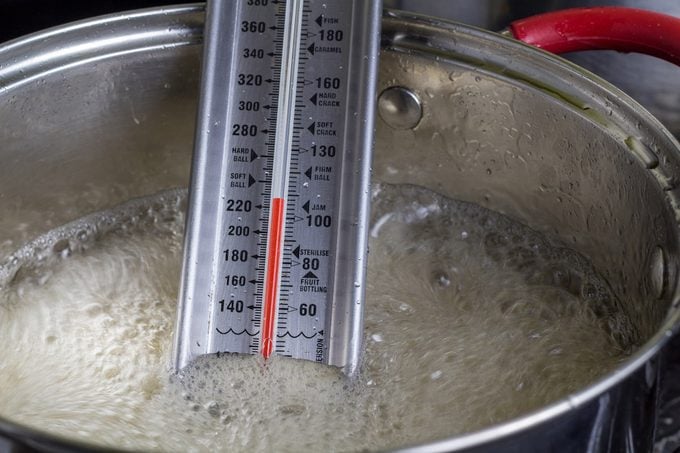 Using a candy thermometer to make homemade candy.