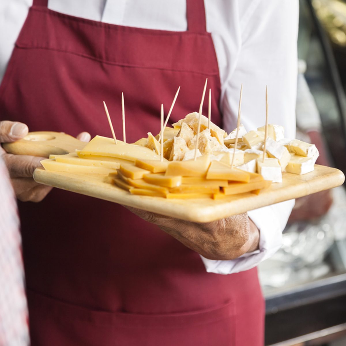 Salesman Holding Cutting Board With Assorted Cheese