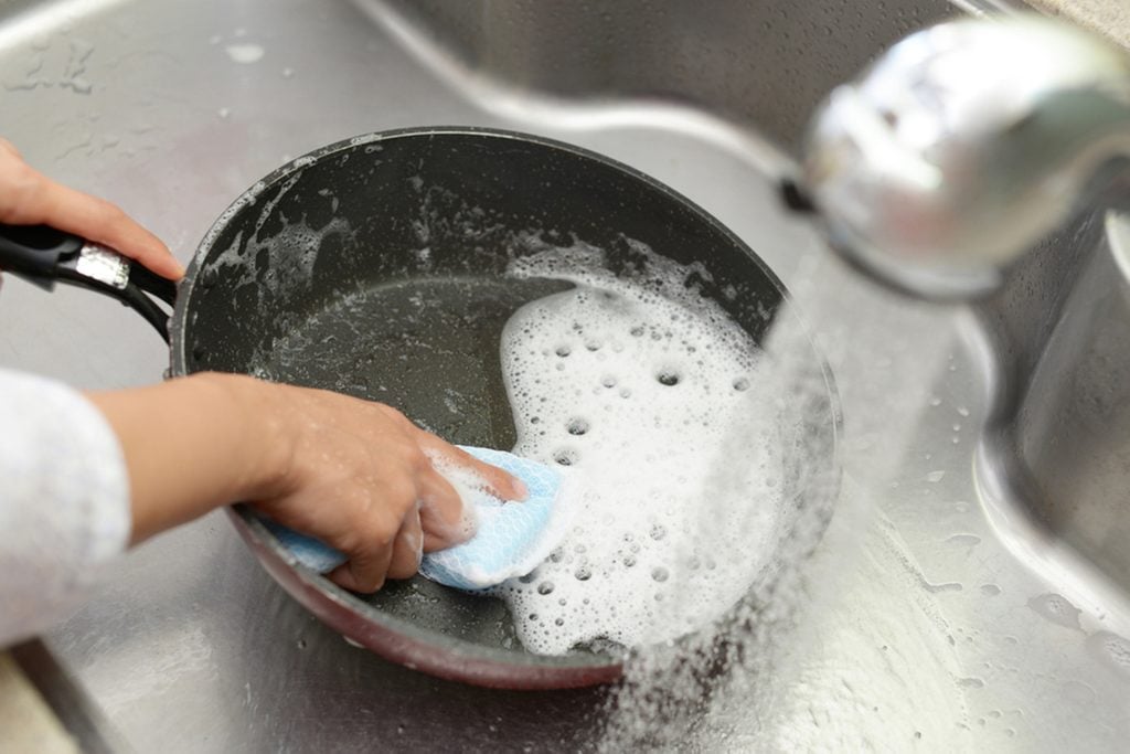 Woman wash the frying pan