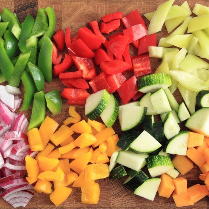 Colored peppers and onions diced on a chopping board