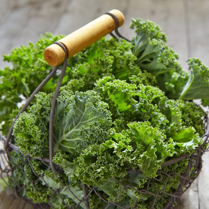 Fresh green kale leaves on wooden table