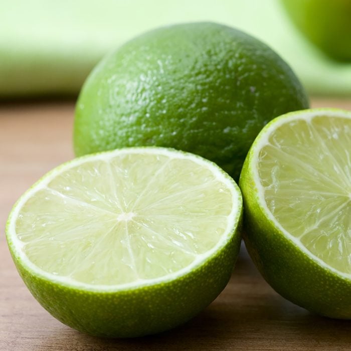 Close-up of cutted green limes on a wooden background.