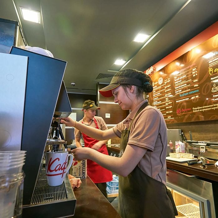 Employee at McDonald's filling a drink