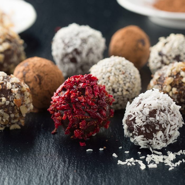 Homemade chocolate and nuts candy balls with cocoa powder, coconut, berries and chopped hazelnuts on black stone background, selective focus; Shutterstock ID 461993434; Job (TFH, TOH, RD, BNB, CWM, CM): Taste of Home