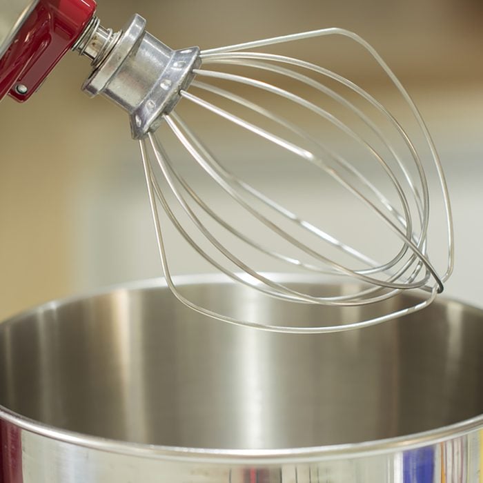 detail of the beater of a red tilt head stand mixer