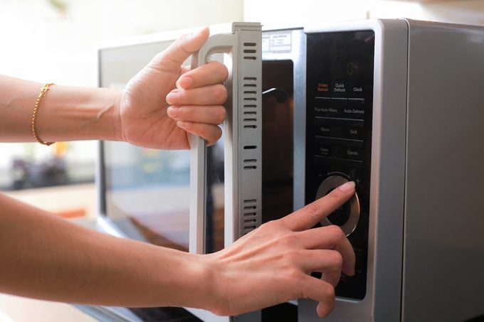 Woman's Hands Closing Microwave Oven Door And Preparing Food in microwave.; Shutterstock ID 735463006