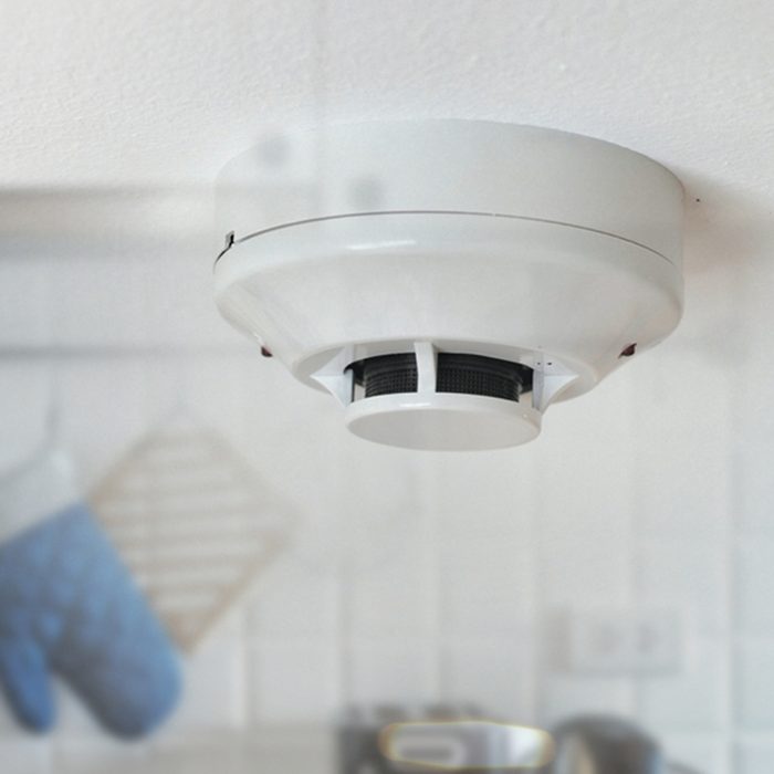 Smoke detector on the ceiling with kitchen background.