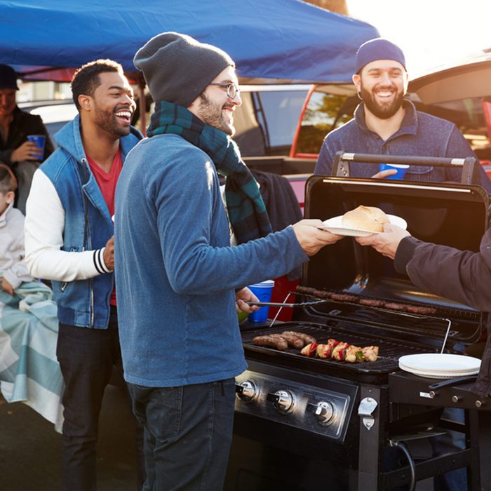 Group Of Sports Fans Tailgating In Stadium Car Park