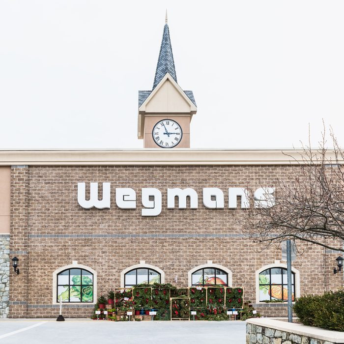 Wegmans grocery store facade and sign with people and Christmas wreath decorations