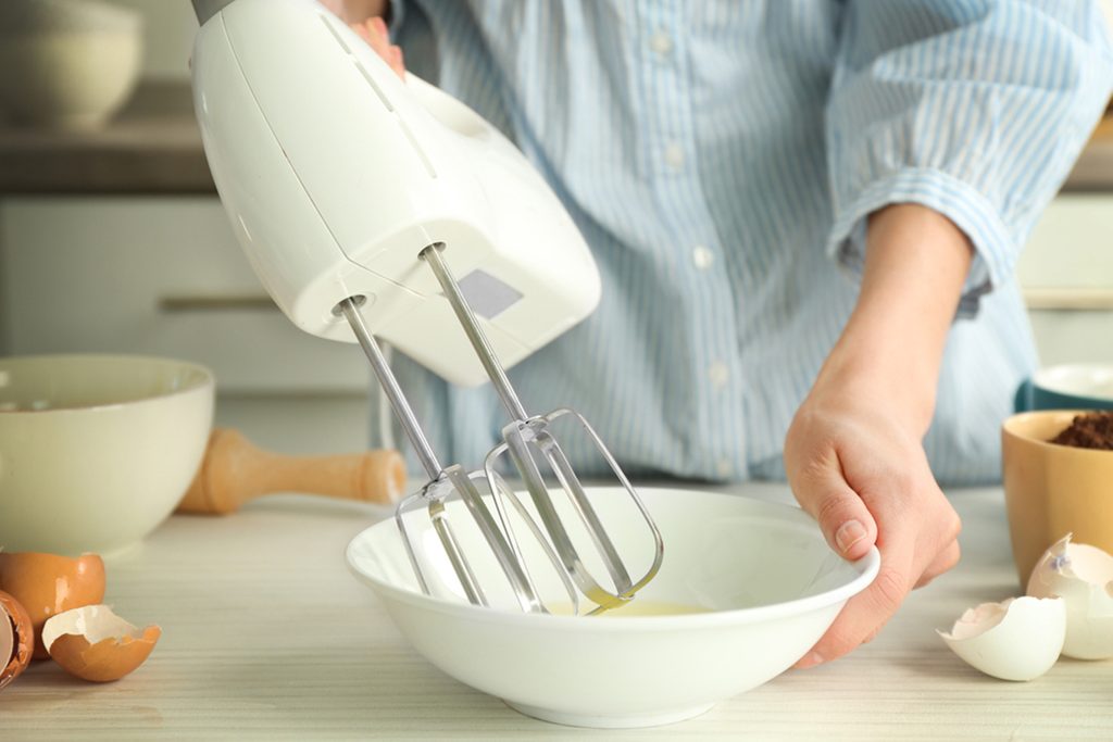 Woman is mixing eggs in a bowl