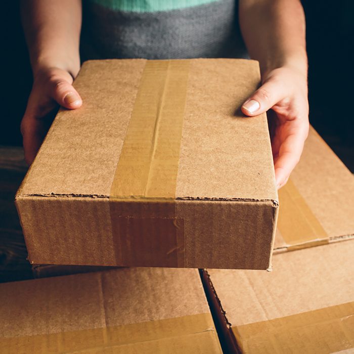 Girl's hands holding the package on the table