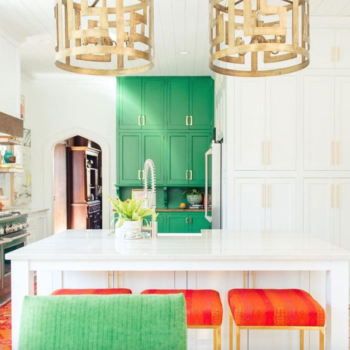Kitchen with bold colored cabinets and chairs