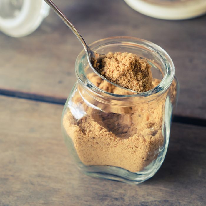 Brown sugar in bottle on wood table, retro color style