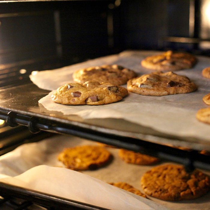 Fresh chocolate chip cookies being baked in an oven