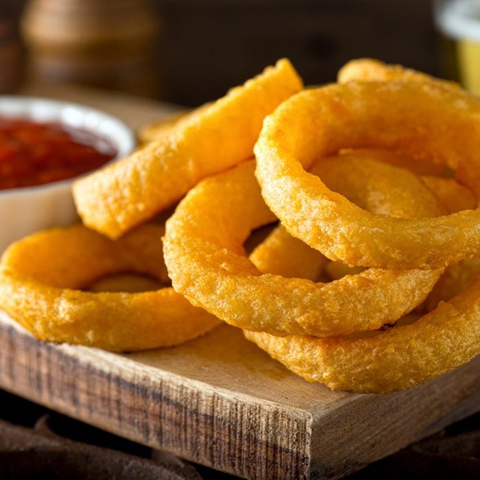 Delicious pub style onion rings with ketchup and beer.