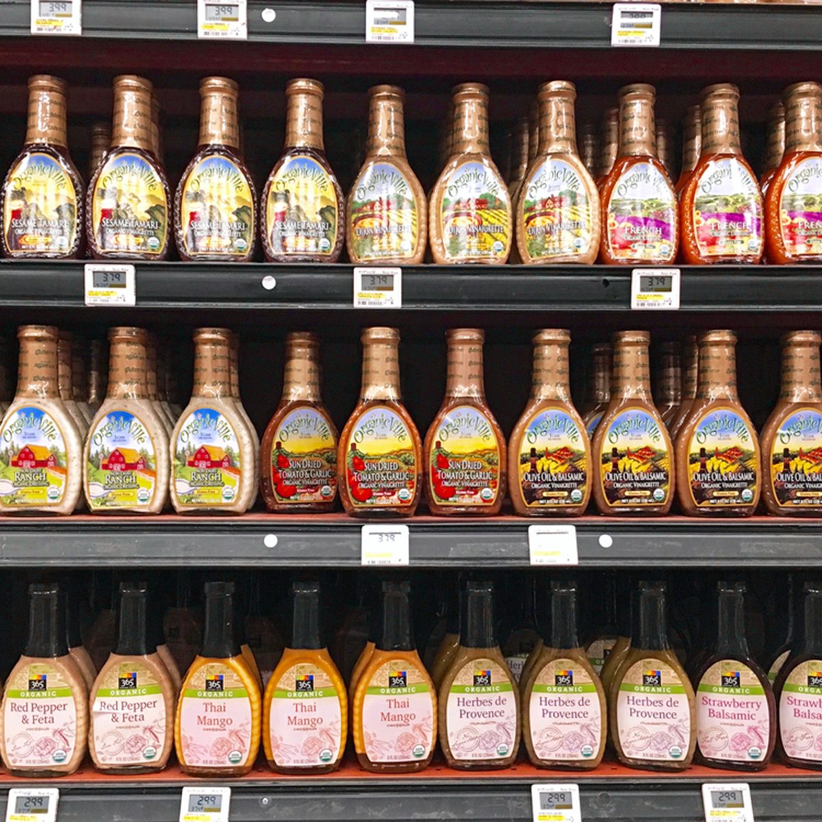 Variety of salad dressing bottles meticulously arranged upon shelving in a local Whole Foods Store in Pasadena, California USA