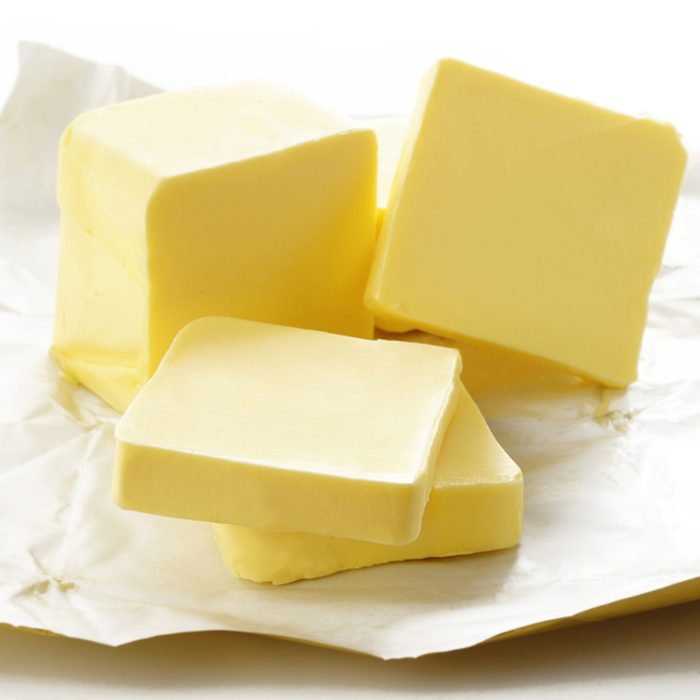 Piece of butter in paper on white background; Shutterstock ID 150754454