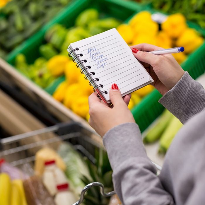 Woman with notebook in grocery store, closeup