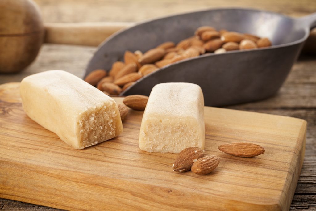 Marzipan bar and almonds on rustic table