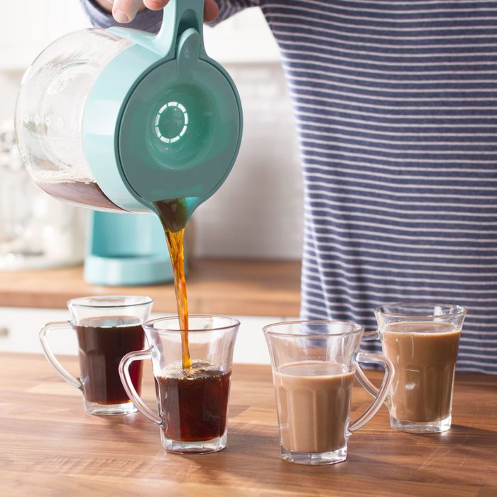 pouring coffee into four different clear coffee mugs