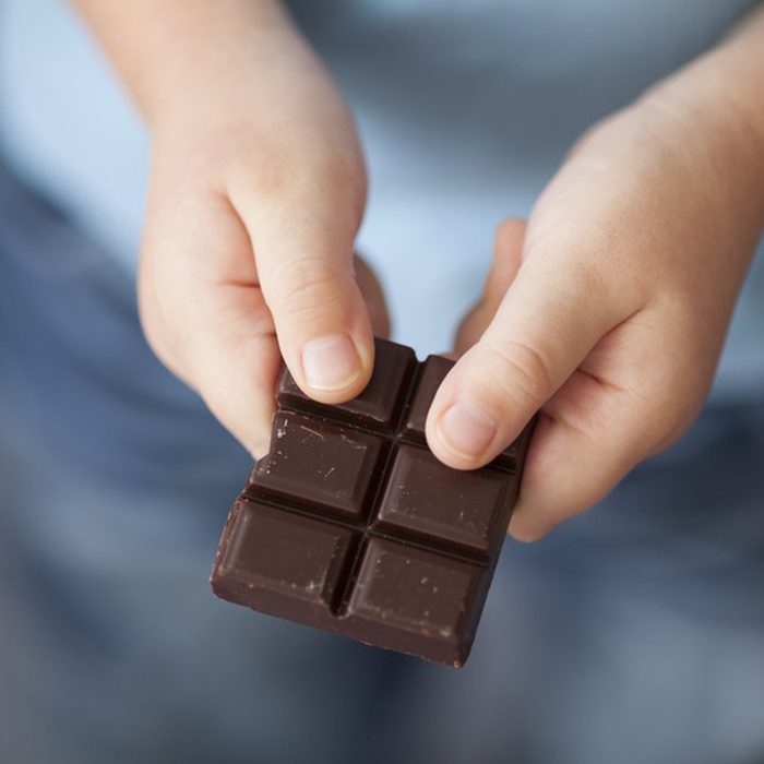 Child breaking off piece of chocolate bar