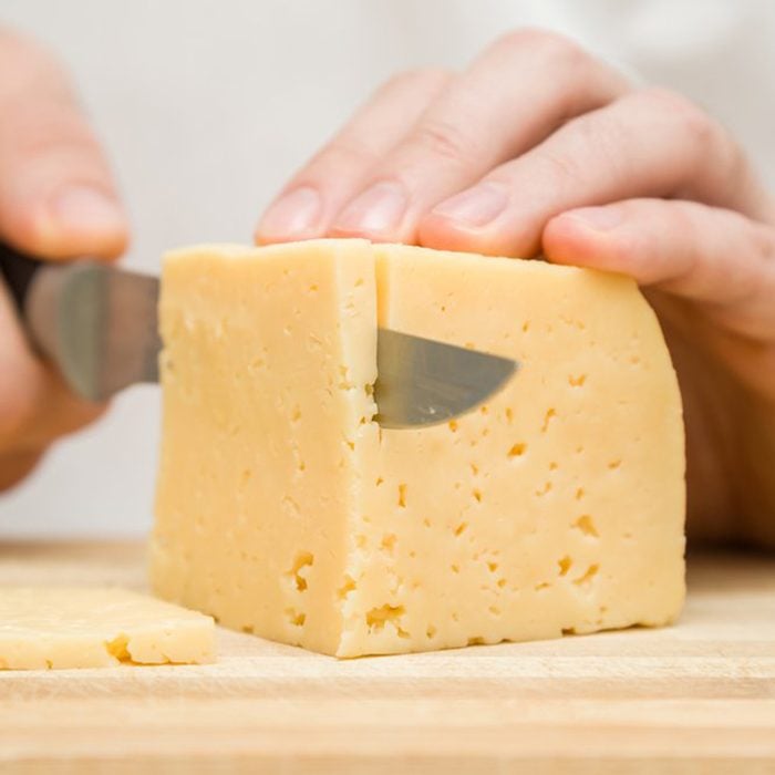 Chef cutting block of cheese