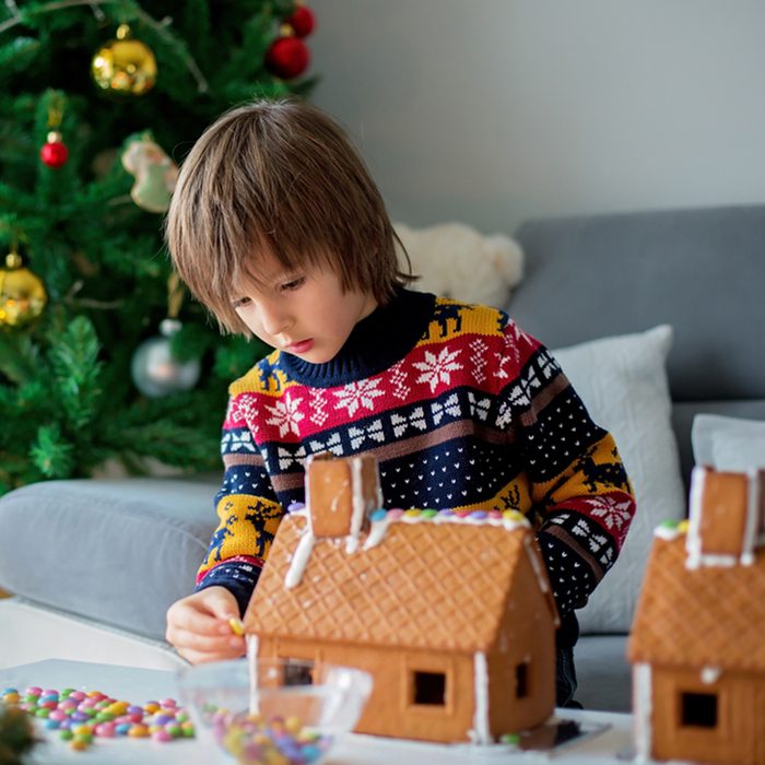 Adorable preschool child, boy, decorating gingerbread houses for Christmas at home
