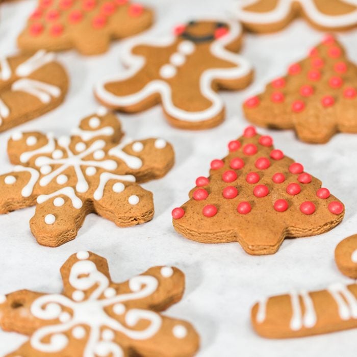 Decorating traditional gingerbread cookies with royal icing for Christmas.