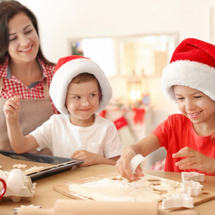 Mother and children making Christmas cookies together at home