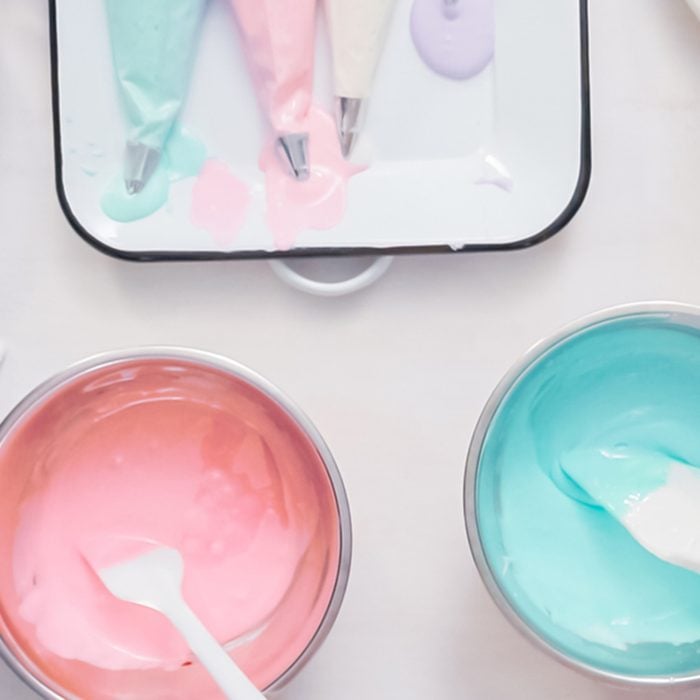 Mixing food coloring into royal icing to decorate unicorn sugar cookies.