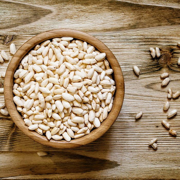 Puffed sweet rice in a round bowl on the old wooden background