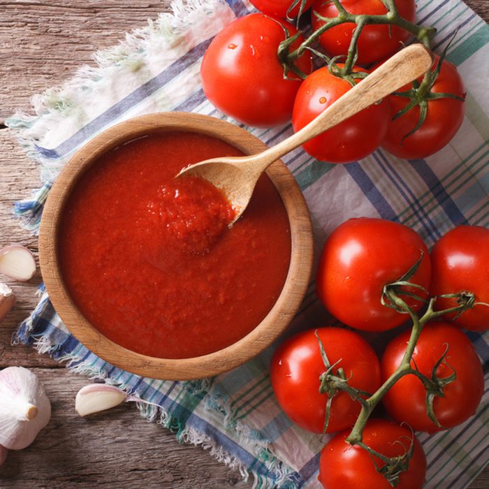 Tomato sauce with garlic and basil in a wooden bowl. horizontal view from above
