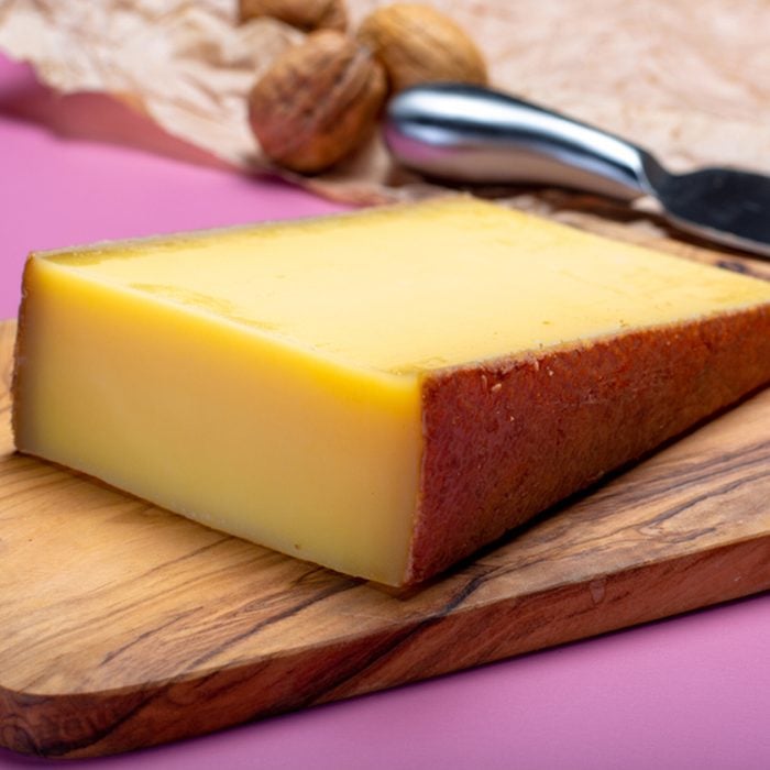 Piece of aged Comte or Gruyere de Comte, AOC French cheese made from unpasteurized cow's milk in the Franche-Comte region of eastern France with traditional methods of production close up.