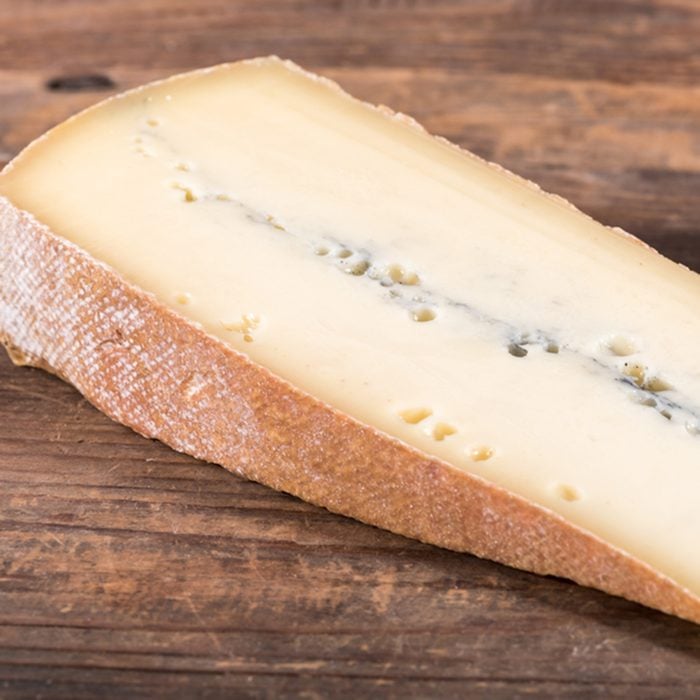 French morbier cheese, on wooden background