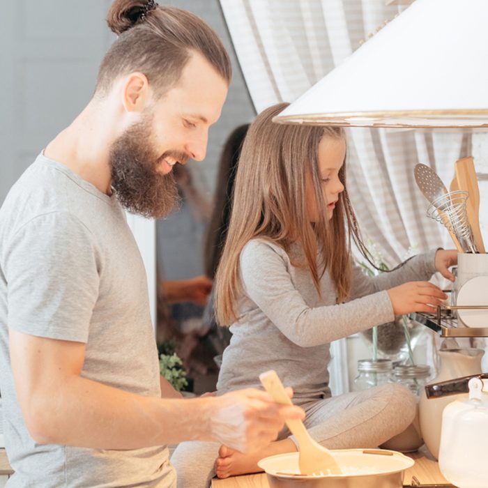 dad and daughter cooking in kitchen.