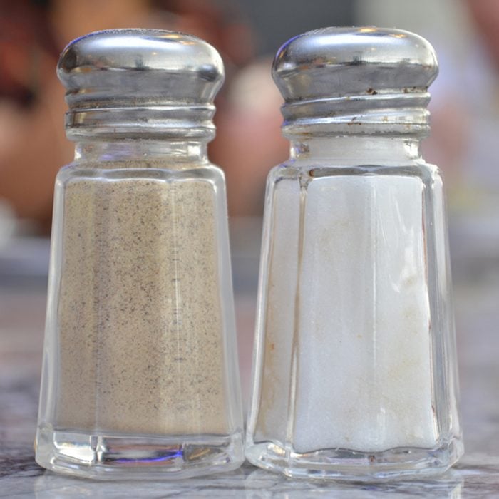 Glass salt and pepper shakers on table in restaurant