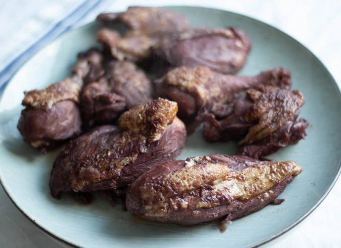 Photo of wine-tinged chicken pieces after removing them from the cooking liquid