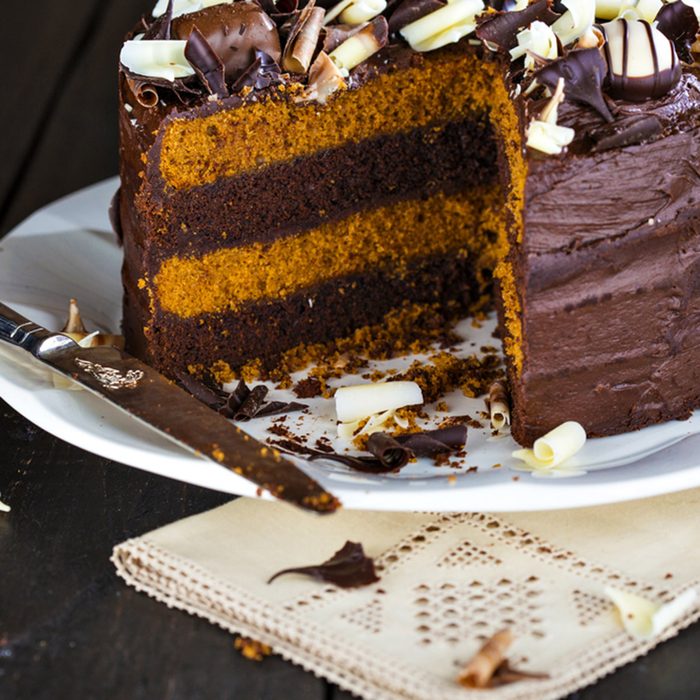Luxury chocolate and toffee layer cake with a slice cut of it.