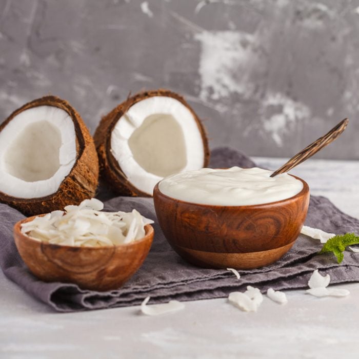 Coconut yogurt in wooden bowl on a dark background