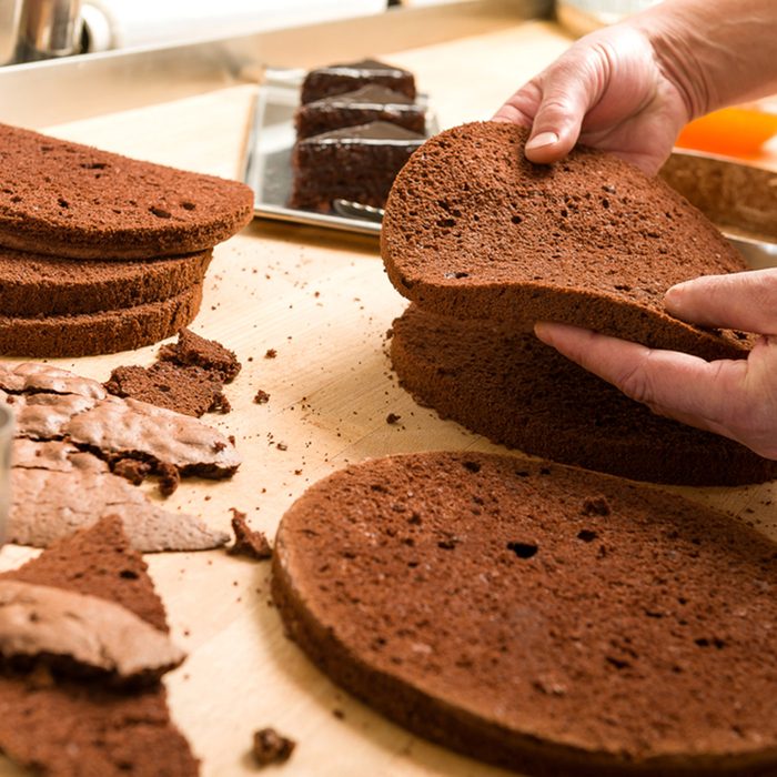 Chef cutting chocolate cake layers and stacking them