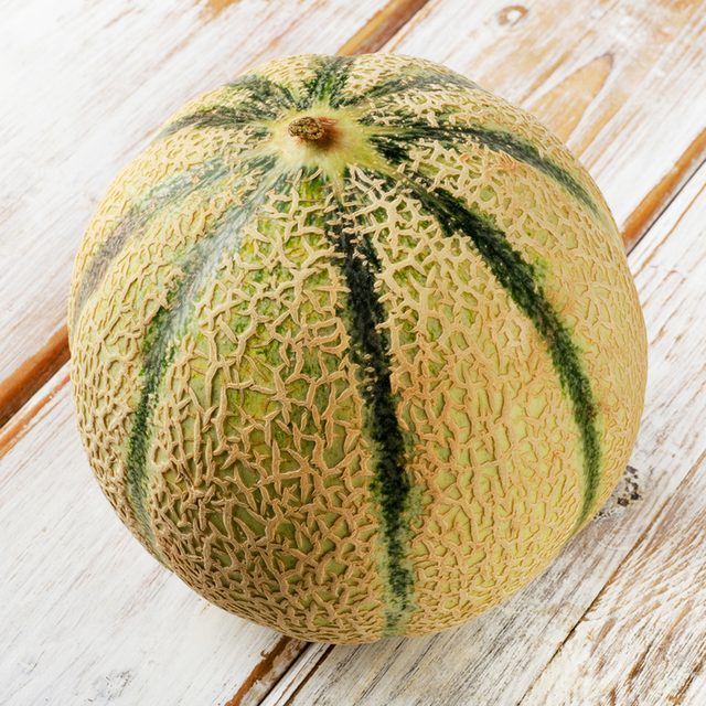 Whole melon on a wooden background.