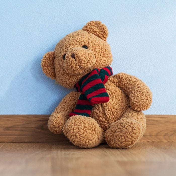 Single teddy bear on a floor in a child room