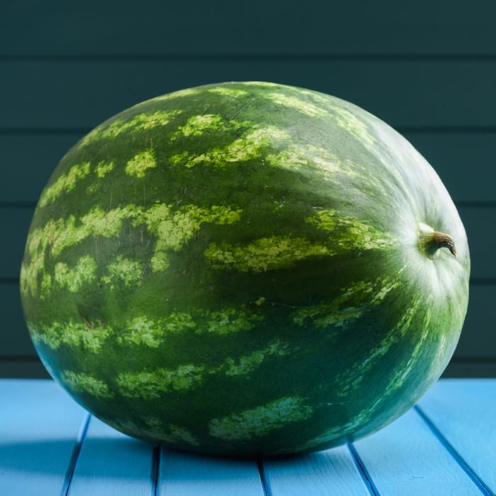 Big whole striped watermelon on blue background