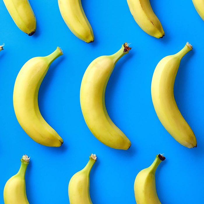 Colorful fruit pattern of fresh yellow bananas on blue background.